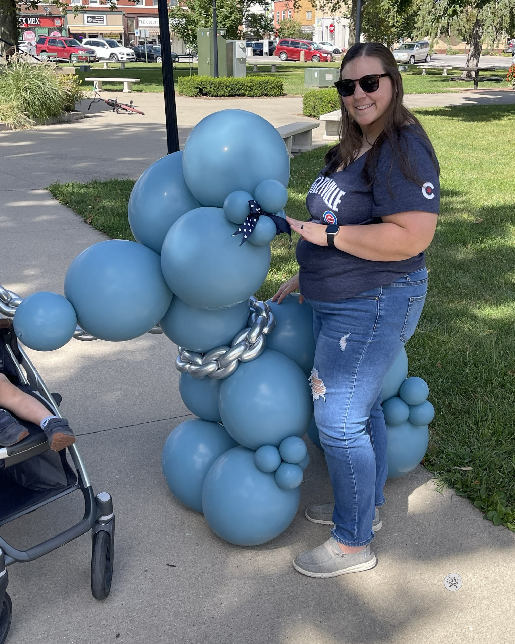 Blue balloon dog sculpture displayed outdoors at a community event.